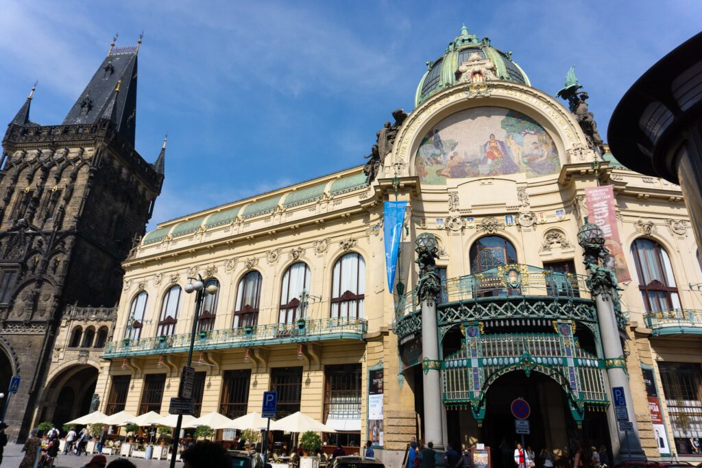 Municipal House beside the Powder Gate in Prague, showing Art Nouveau ornament next to a dark Gothic tower.