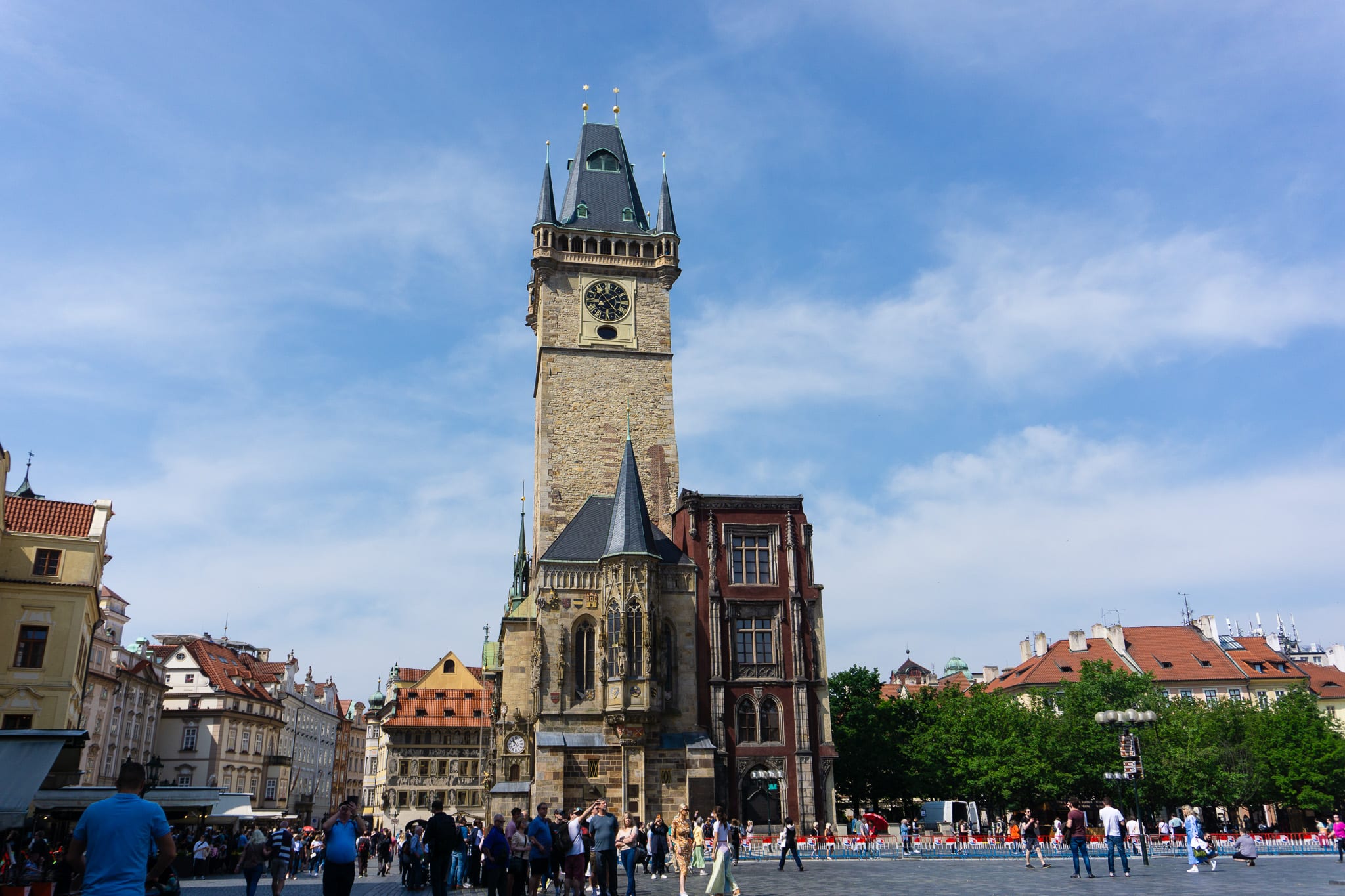 Old Town Hall tower and public square in Prague under a blue sky.