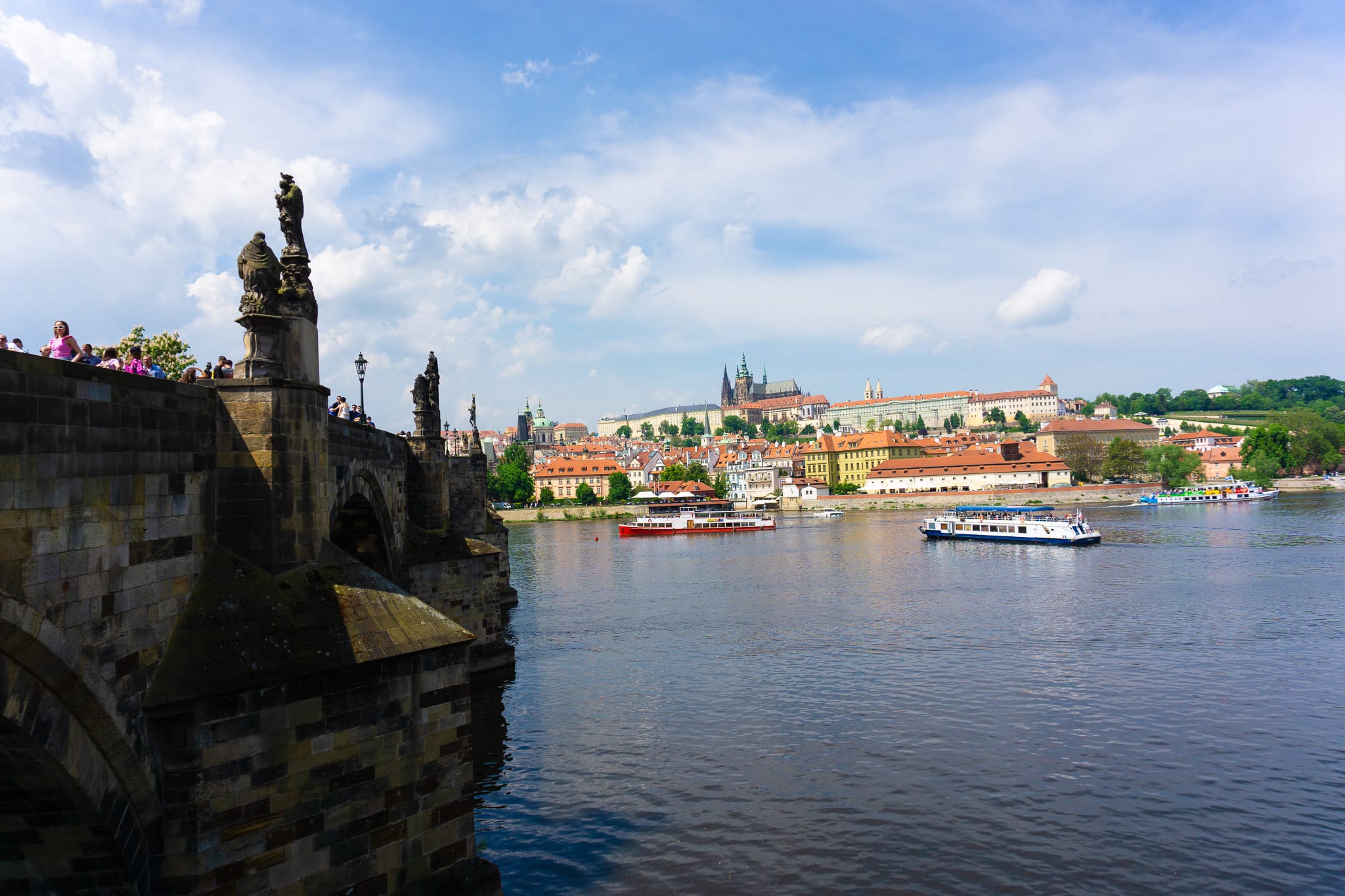 Charles Bridge over the Vltava River with Prague’s historic skyline beyond.