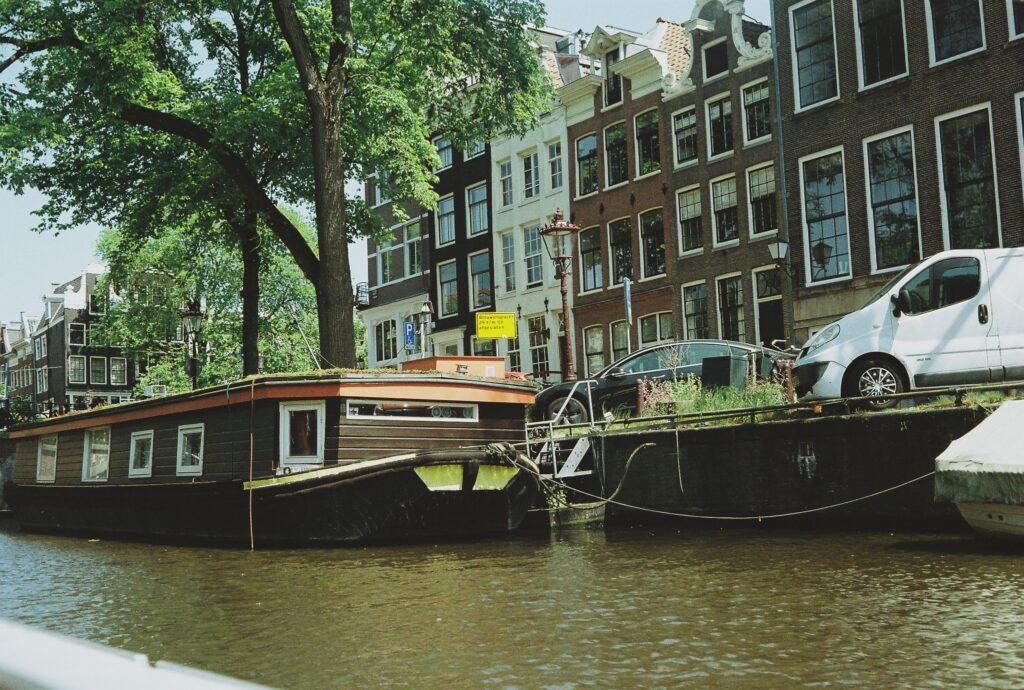 Brouwersgracht in Amsterdam with canal houses, moored boats, trees, and canal-side street signage