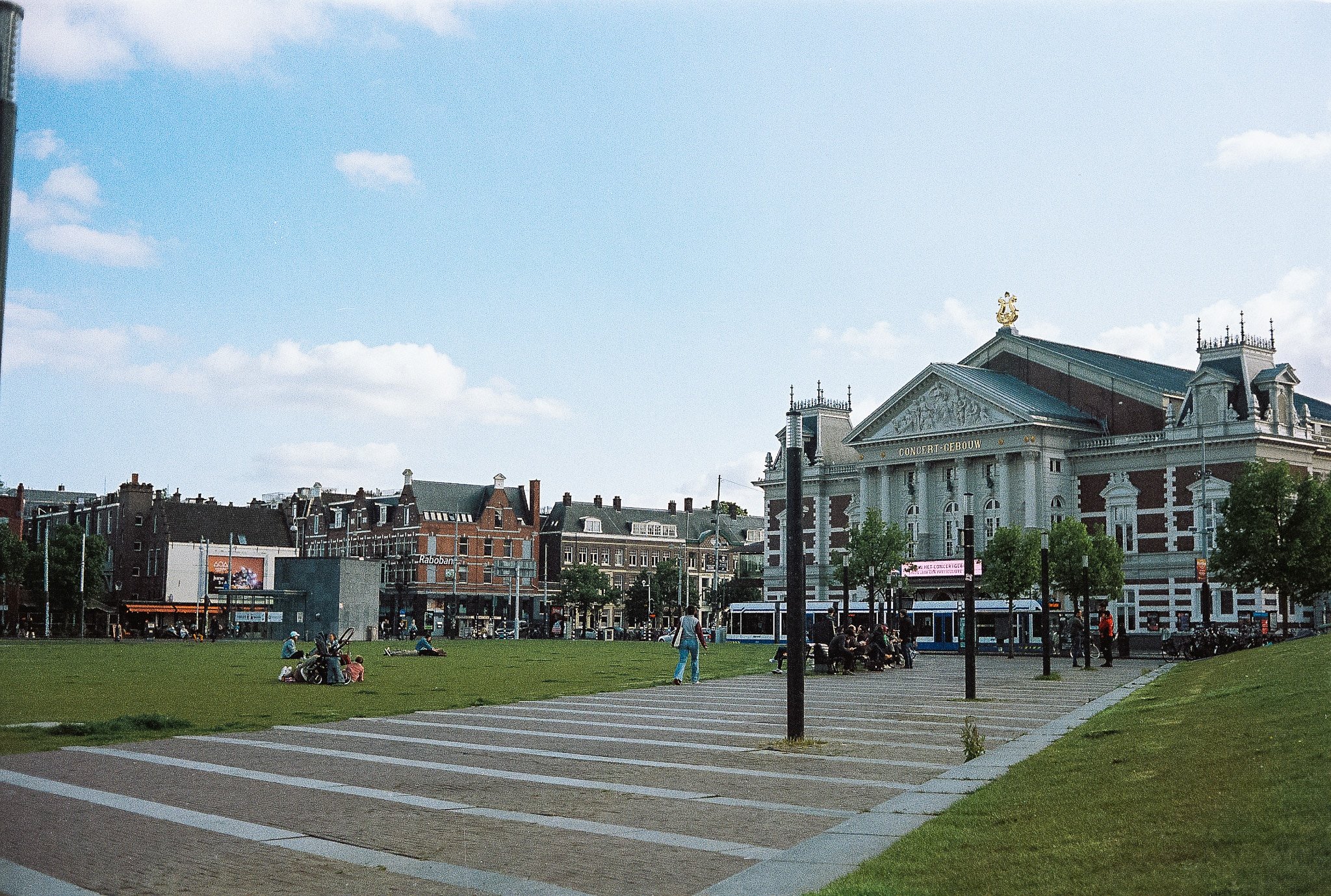 Het Concertgebouw in Amsterdam facing Museumplein lawn with tram and people in the foreground