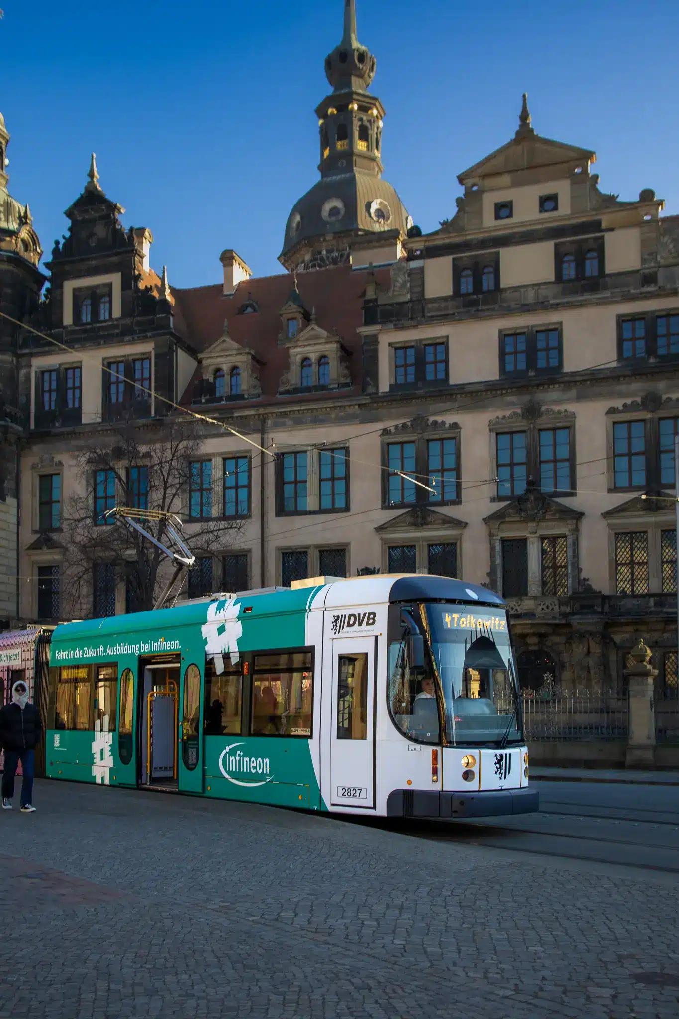 Yellow tram with Infineon advertisement in front of historic Dresden building