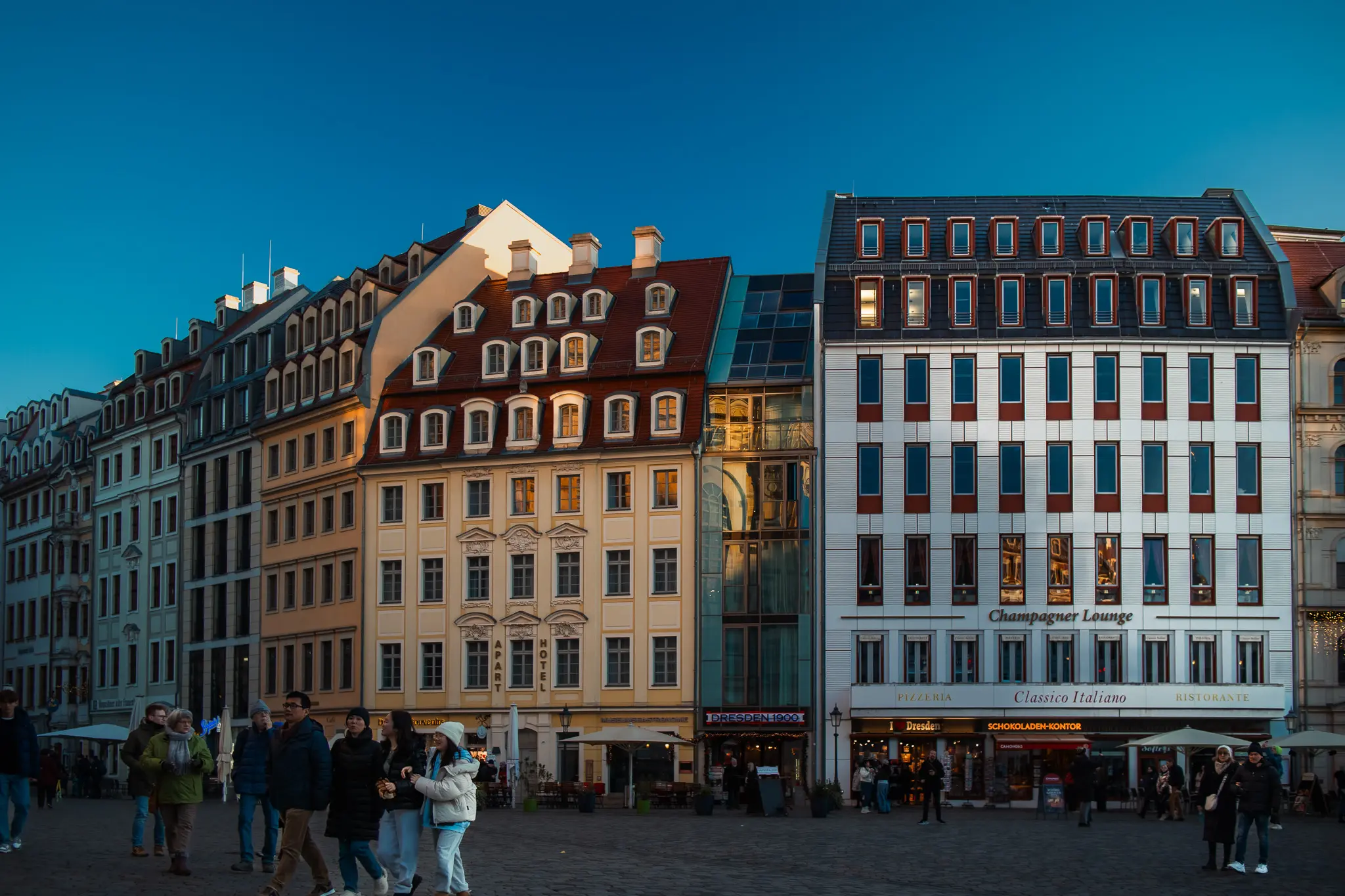 Historic buildings with signs for apart hotel, restaurants, and Schokoladen-Kontor in Dresden