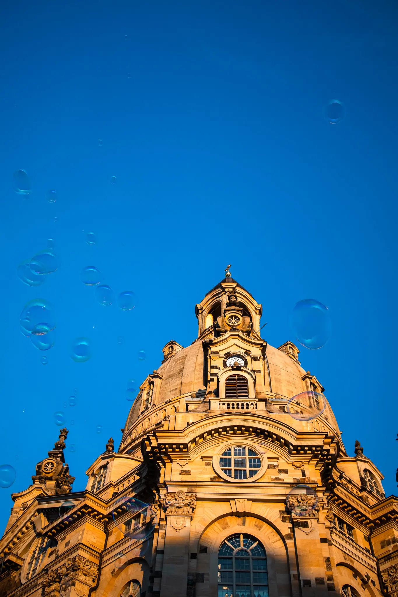 Soap bubbles floating in front of an ornate domed historic building in Dresden