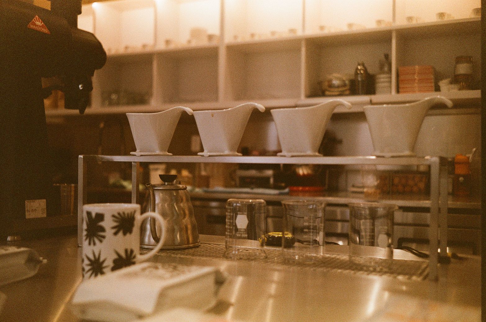 Specialty coffee setup with pour-over drippers and kettle in a warm interior