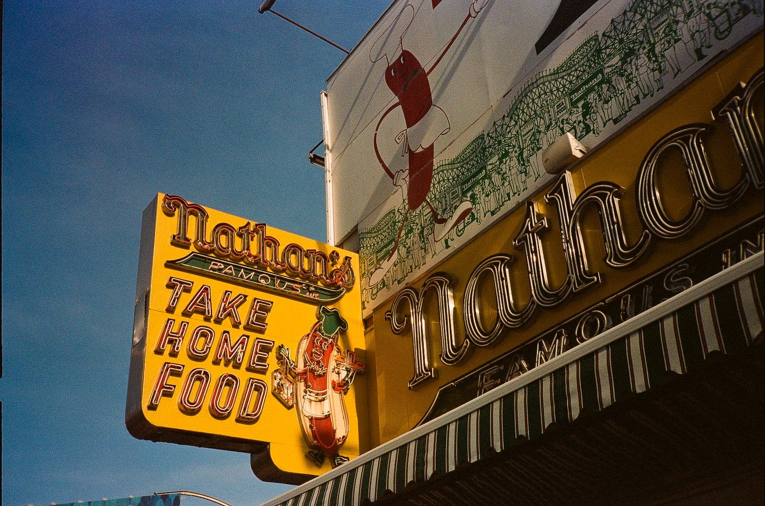 Low-angle view of Nathan's Famous signage and facade at Coney Island in Brooklyn.