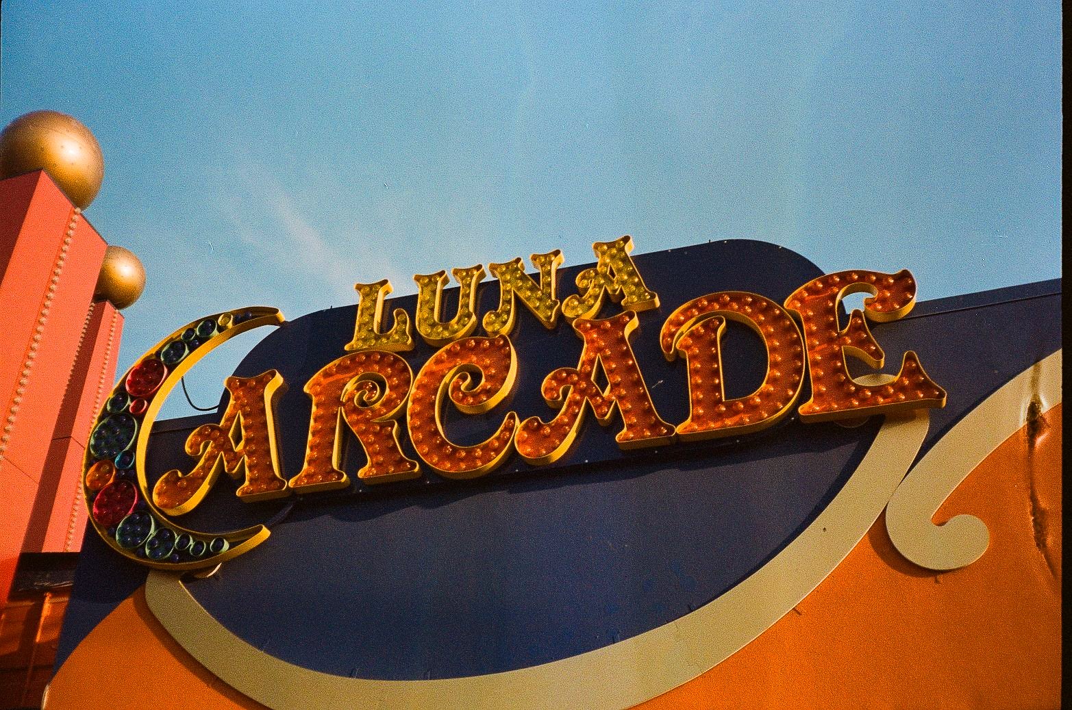 Illuminated Luna Arcade sign with ornate bulb-lit lettering and decorative amusement facade.