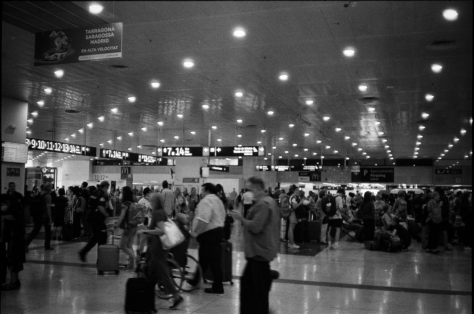 Busy transport concourse with signage for Tarragona Zaragoza and Madrid high-speed travel