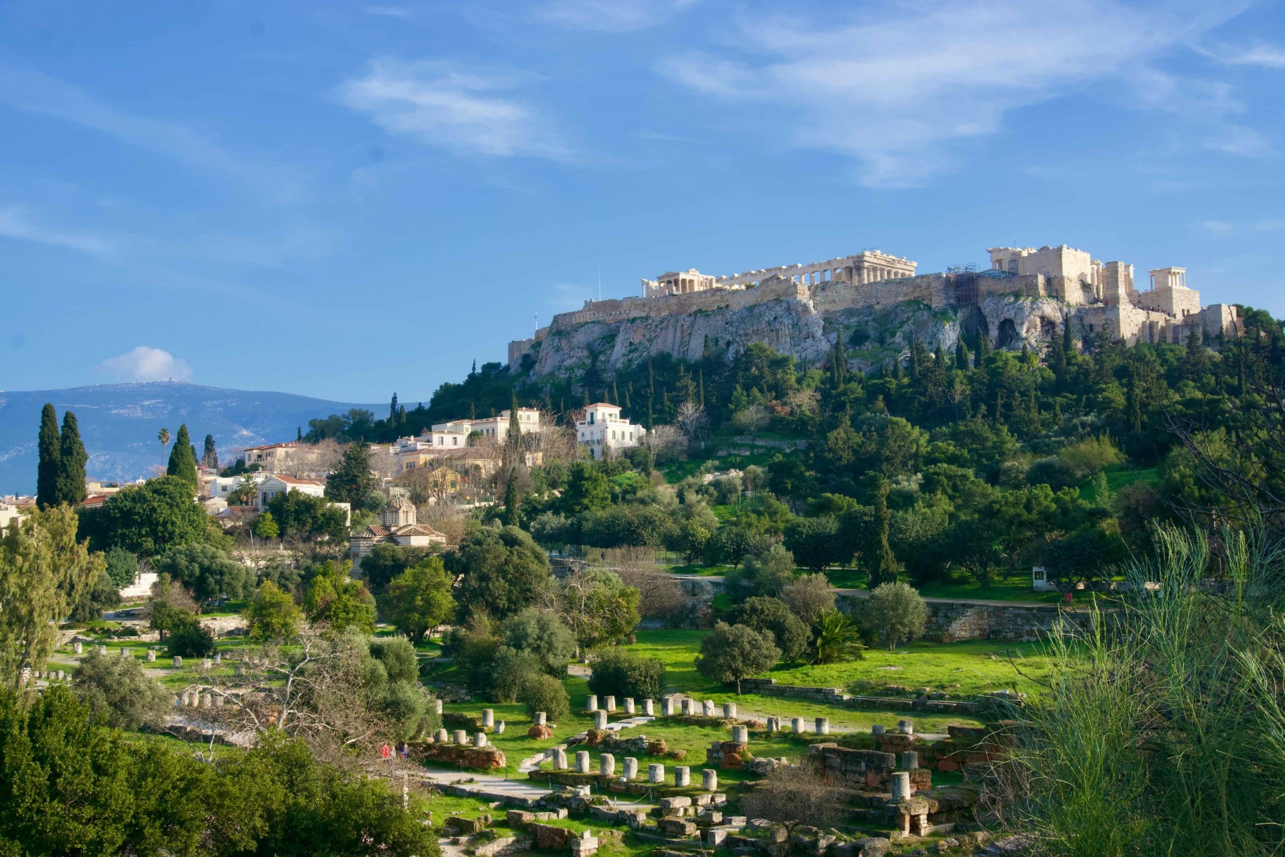 Wide view of the Acropolis hilltop complex above lower ruins and residential Athens
