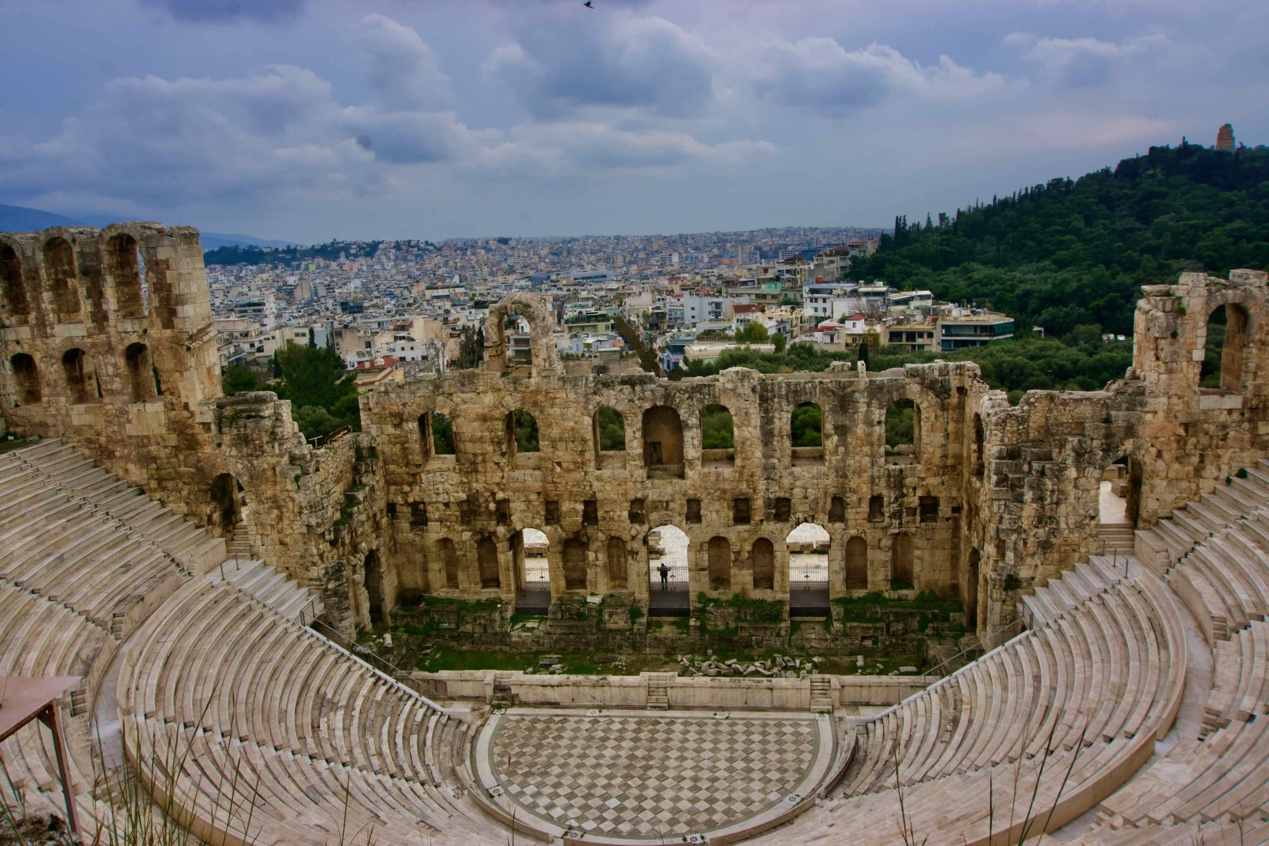 Ancient theater on the Acropolis slope overlooking the dense urban skyline of Athens