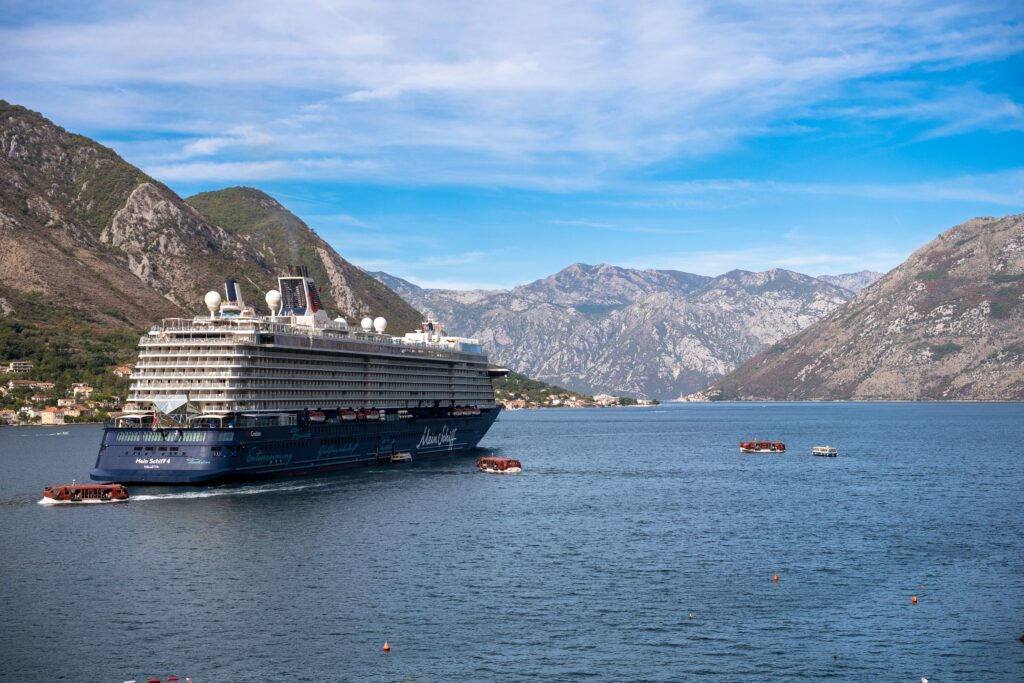Cruise ship on the Bay of Kotor with mountains behind.